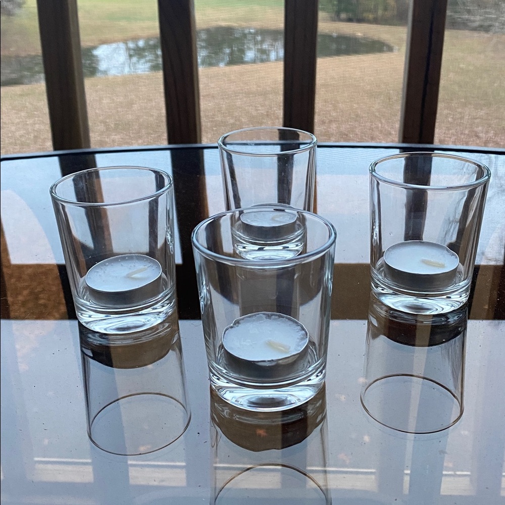 4 clear glass votive candle holders with 33 ITALY impressed on the bottom.